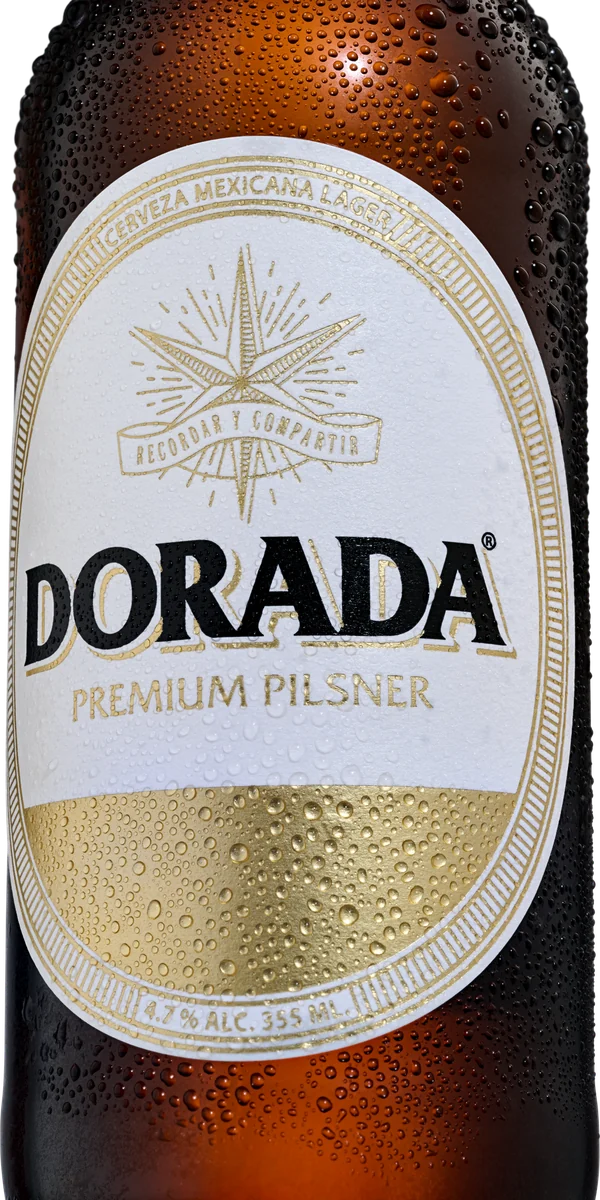 Acercamiento a la etiqueta oval de DORADA Premium Pilsner, con condensación sobre la botella